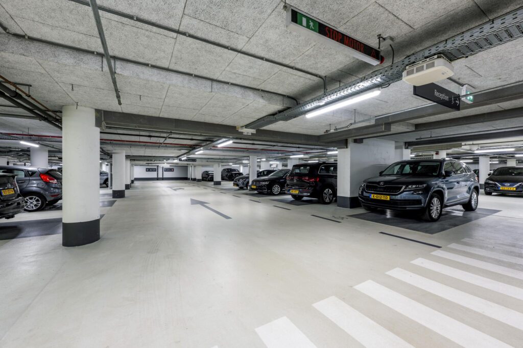 Underground parking garage with several parked cars at Mr. Treublaan.